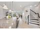 Open concept kitchen with island, overlooking living area and stairs at 594 Piazza Pt, Oviedo, FL 32765