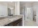 Bathroom with granite countertop, dark brown vanity, and a walk-in shower at 594 Piazza Pt, Oviedo, FL 32765