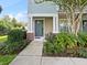 Townhouse entryway with gray door and landscaping at 594 Piazza Pt, Oviedo, FL 32765