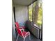Screened porch with two red chairs and a view of the backyard at 4743 S Texas Ave # 4743B, Orlando, FL 32839