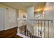 Upstairs hallway with dark hardwood floors and white railings at 221 Las Fuentes Dr, Kissimmee, FL 34746