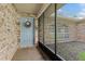 Enclosed front porch with light blue door and brick exterior at 1150 Woodchuck Ct, Orange City, FL 32763