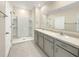 Bathroom with double vanity, large mirror, and shower at 309 Gina Ln, Davenport, FL 33837