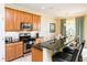 Modern kitchen with wood cabinets and breakfast bar at 7582 Assembly Ln, Reunion, FL 34747