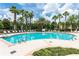 Community pool with lounge chairs and palm trees at 7582 Assembly Ln, Reunion, FL 34747