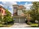 A stunning three-story home with a two-car garage, landscaped yard and stucco exterior at 1169 Castle Pines Ct, Reunion, FL 34747