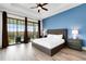 Main bedroom with king-size bed, large windows, and access to a balcony at 1169 Castle Pines Ct, Reunion, FL 34747