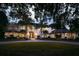 Two story luxury home with palm trees and circular driveway at night at 5121 Latrobe Dr, Windermere, FL 34786