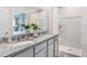 Double vanity bathroom with granite countertops, shower, and view to bedroom at 2563 Sage Valley Way, Winter Haven, FL 33884