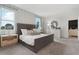 Main bedroom with gray upholstered bed and light gray carpeting at 5945 Cliffbow Loop, Leesburg, FL 34748