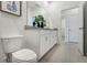Bathroom with toilet and double vanity with granite countertop at 5945 Cliffbow Loop, Leesburg, FL 34748