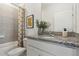 Bathroom with granite countertop, shower/tub combo, and neutral tile at 5945 Cliffbow Loop, Leesburg, FL 34748