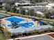 Aerial view of a community pool with a water slide, deck, and shaded seating areas at 5945 Cliffbow Loop, Leesburg, FL 34748