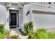 Home's exterior entryway with a dark door and landscaping at 16559 Centipede St, Clermont, FL 34714