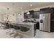 Modern kitchen with dark cabinetry, granite counters, and stainless steel appliances at 3369 Lilac Way, Davenport, FL 33897