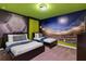 Bedroom with two twin beds, stadium wall mural, and green accent wall at 1406 Moon Valley Dr, Davenport, FL 33896