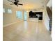 Open living room with tile floors, kitchen island, and staircase at 8282 Tavistock Lakes Blvd, Orlando, FL 32827