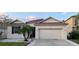 One-story home with a light beige exterior, brown roof, and attached garage at 13038 Oulton Cir, Orlando, FL 32832