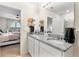 Double vanity bathroom with granite countertop and view of bedroom at 1220 Sugarwood St, Davenport, FL 33837