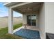 Covered patio with string lights, small table, and blue patterned rug at 1220 Sugarwood St, Davenport, FL 33837