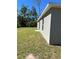 View of the house exterior, highlighting the gray siding and lawn at 3402 Sw 165Th Loop, Ocala, FL 34473