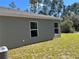 Gray house exterior with large windows and a grassy yard at 3402 Sw 165Th Loop, Ocala, FL 34473