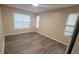 Bright bedroom featuring wood-look flooring and neutral walls at 5600 Devonbriar Way # N202, Orlando, FL 32822