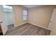 Well-lit bedroom with wood-look floors and neutral walls at 5600 Devonbriar Way # N202, Orlando, FL 32822