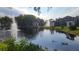 Tranquil pond reflecting surrounding buildings and sky at 5600 Devonbriar Way # N202, Orlando, FL 32822