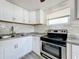 Bright kitchen boasts white cabinets, granite countertops, and stainless steel appliances at 653 W Thomas St, Lakeland, FL 33805