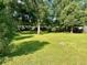 Large grassy backyard with mature trees at 511 W Gardenia Dr, Orange City, FL 32763