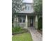Green two-story home with a purple door and landscaped walkway at 8282 Tavistock Lakes Blvd, Orlando, FL 32827