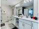 Double vanity bathroom with white cabinets and a large mirror at 3161 Paradox Cir # 101, Kissimmee, FL 34746