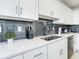 Modern kitchen with white cabinets, gray backsplash, and stainless steel appliances at 3161 Paradox Cir # 101, Kissimmee, FL 34746