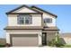 Two-story house with neutral siding, gray garage door, and manicured lawn at 1909 Cayman Cove Cir, St Cloud, FL 34772