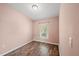 Light pink bedroom with wood-look floors and a window with blinds at 8850 Grand Palms Circle # B, Kissimmee, FL 34747