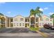 Condo building showcasing light beige walls, multiple units, and palm trees at 8850 Grand Palms Circle # B, Kissimmee, FL 34747
