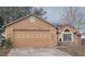 Tan house with a two-car garage and solar panels at 2618 Coventry Ln, Ocoee, FL 34761