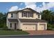 Two-story house, beige siding, three-car garage, and landscaping at 2655 Great Heron Ave, Saint Cloud, FL 34771