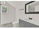 Clean bathroom featuring a shower, toilet and gray vanity at 500 N 13Th St, Leesburg, FL 34748
