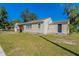Tan house with a black shed and a grassy yard at 112 S Moss St, Leesburg, FL 34748