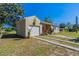Tan house with white garage door and a landscaped yard at 112 S Moss St, Leesburg, FL 34748