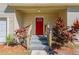 Red front door entrance with wooden steps and tropical plants at 112 S Moss St, Leesburg, FL 34748