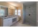 Bathroom with granite countertop, double vanity, and shower at 112 S Moss St, Leesburg, FL 34748