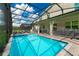 Relaxing pool and spa with screened enclosure and lush landscape at 2816 Simile St, Kissimmee, FL 34746