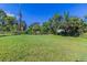 Large grassy backyard with mature trees and chain link fence at 1300 Mercy Dr, Orlando, FL 32808