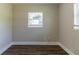 Empty bedroom with dark wood-look flooring and a window with blinds at 1300 Mercy Dr, Orlando, FL 32808