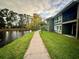 Peaceful waterfront pathway with lush landscaping at 6110 Peregrine Ave # E05, Orlando, FL 32819