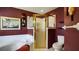 Bathroom with corner bathtub, shower, and burgundy walls at 5825 Princess Caroline Pl, Leesburg, FL 34748