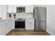 Modern kitchen with white cabinets, stainless steel appliances, and wood-look flooring at 2364 Silver Palm Dr, Kissimmee, FL 34747